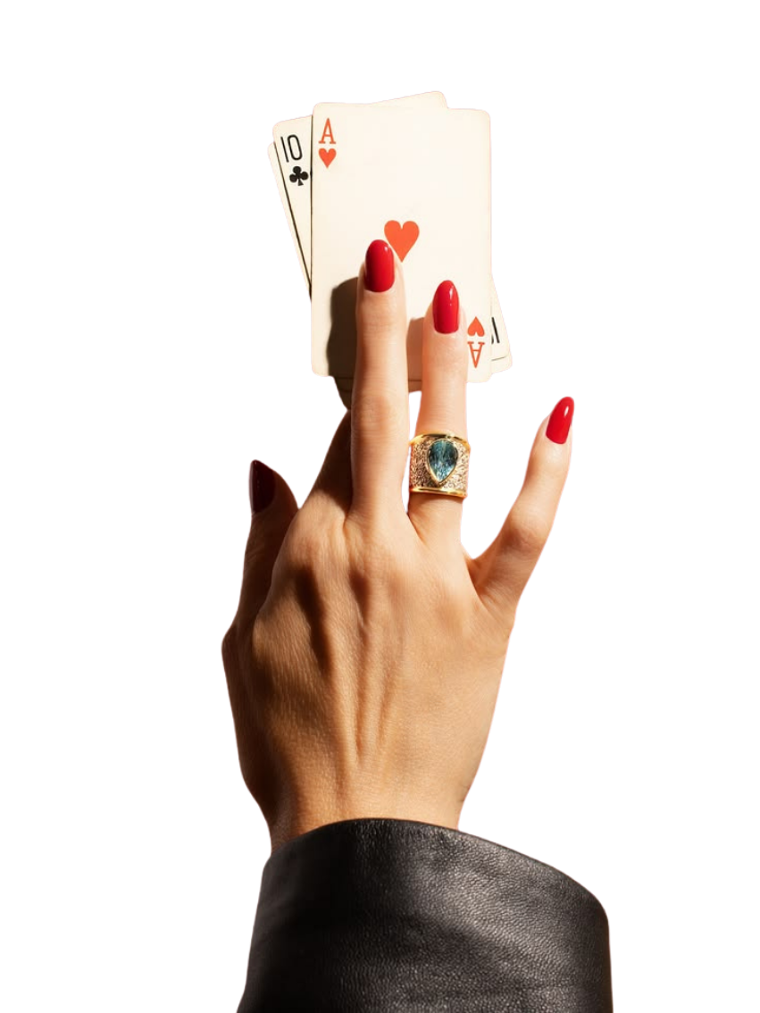 A hand with red nails holding an ace of hearts and ten of clubs